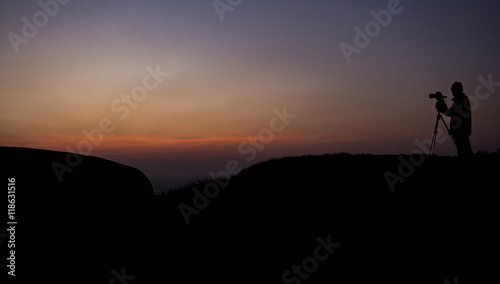 silhouette photographer on the top of the mountain  dark tone and vignette