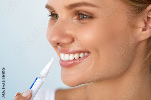 Healthy White Teeth. Beautiful Smiling Woman Using Whitening Pen. High Resolution Image