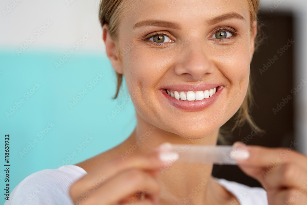 Woman With Healthy White Teeth Using Teeth Whitening Strip. High Resolution Image Woman With Healthy White Teeth Using Teeth Whitening Strip. High Resolution Image