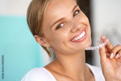 Smiling Woman With White Teeth Holding Teeth Whitening Tray. High Resolution Image photo