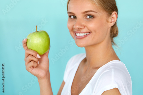 Smiling Woman With Beautiful Smile, White Teeth Holding Apple. High Resolution Image