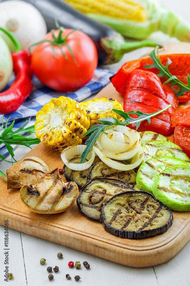 Grilled tomato, corn, eggplant, mushroom, bell pepper, marrow and onion on a table. Healthy prepared food with ingredients.