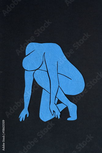 Cut-out blue paper male figure on black background