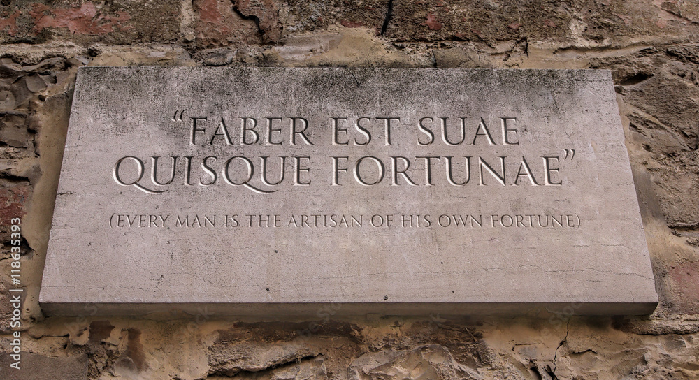 Faber est suae quisque fortunae. A Latin phrase meaning Every man is the artisan of his own fortune. Engraved text.
