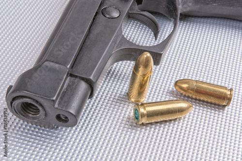 Bullets and gun on aluminium background