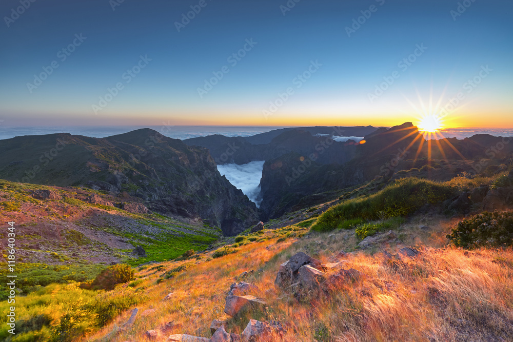 Sunset over mountains of Madeira island above the clouds at Pico do Arieiro and Pico Ruivo