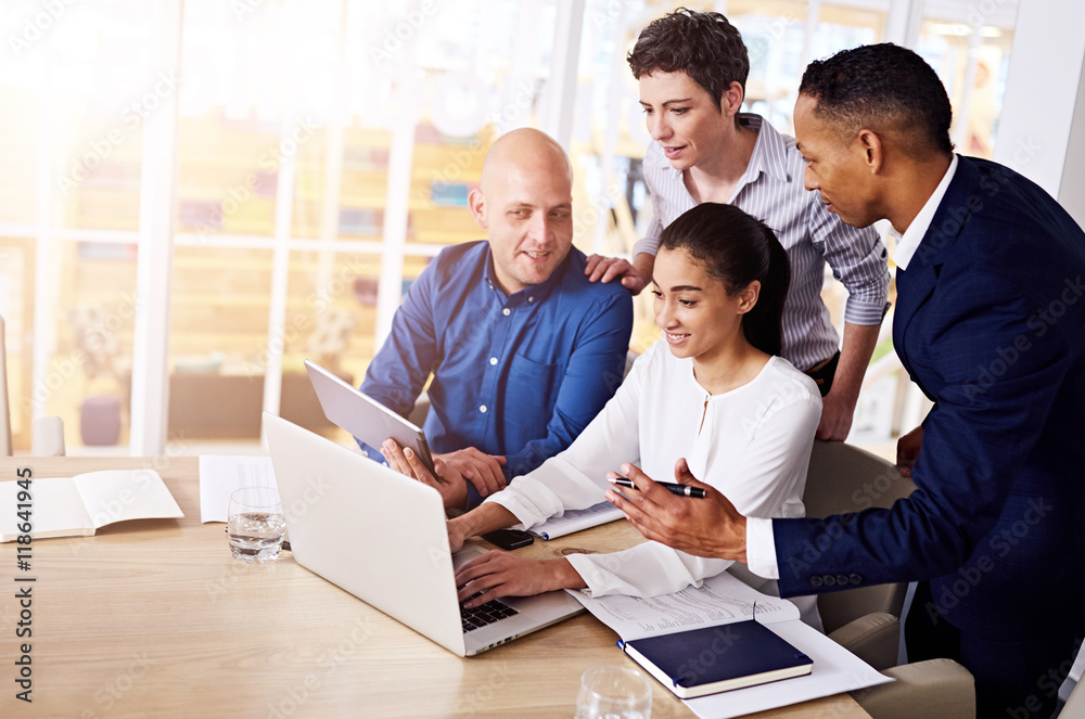 eclectic group of 4 entrepreneurs engaging in an online conversation via video conference using a laprop to discuss possible foreign production to save on labour costs.