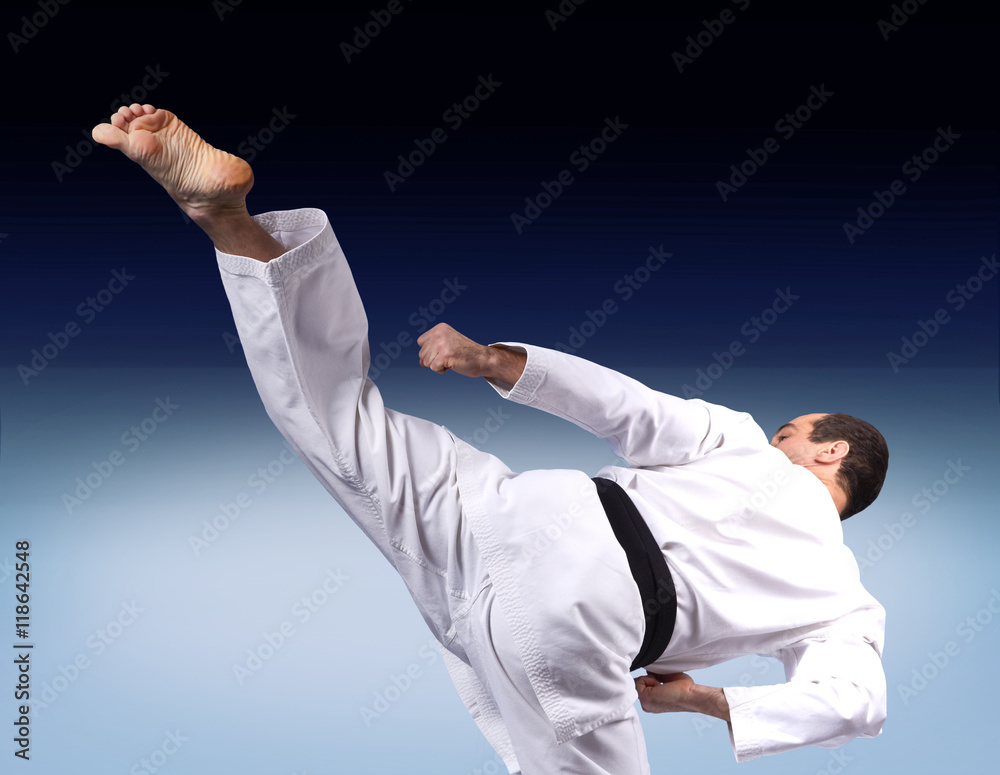 Adult karate athlete beats roundhouse kick leg