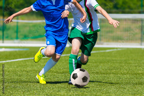 young boys playing football soccer game. Running players in blue and white uniforms