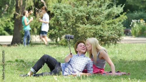 Wallpaper Mural Young Couple Have Picnic Lying on a Lawn Filming Sitting on a Green Grass in Park Teenagers at the Nature Friends Couples Spend Time in Sunny Summer Day Torontodigital.ca