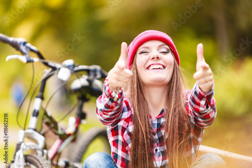girl relaxing in autumnal park with bicycle.