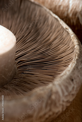 uncooked portobello mushrooms, isolated on a brown cutting board, closeup, vertical