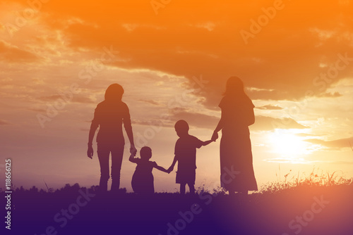 Happy family dancing on the road in the sunset time. Evening par