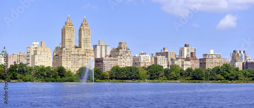 Central Park reservoir with fountain with Upper West Side skyline and blue sky with clouds, Manhattan, New York City photo