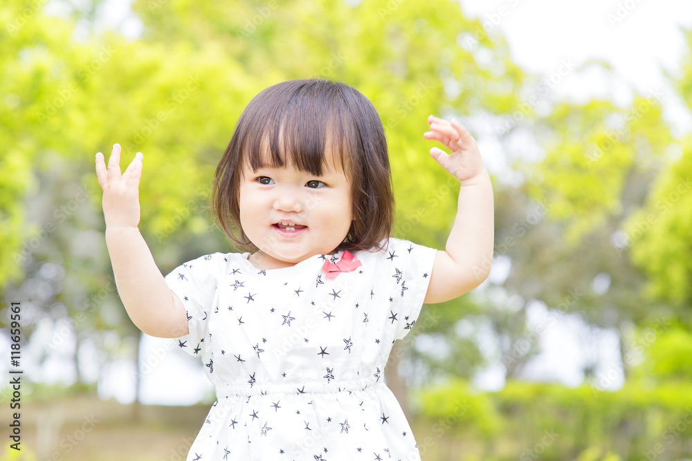 新緑の中で見つめる幼い女の子