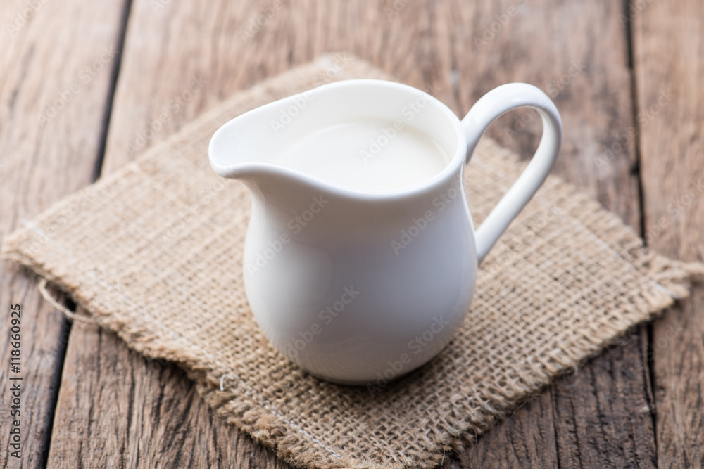 Milk in jug on wood table Milk in jug on wood table