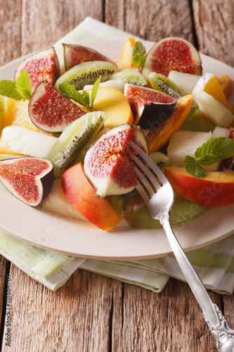 Healthy Fruit salad with fig, peach, melon, kiwi and orange close-up. vertical
