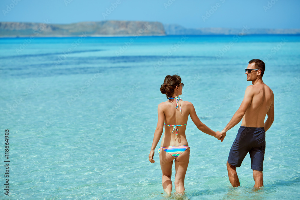 young happy couple in love walking on the beach at the sunny day. Balos beach, Crete, Greece. newlyweds in a honeymoon on the sea and islands young happy couple in love walking on the beach at the sunny day. Balos beach, Crete, Greece. newlyweds in a honeymoon on the sea and islands