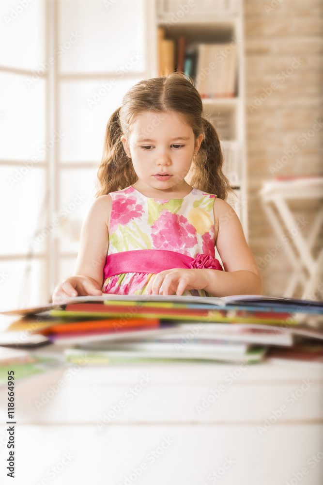 Indoor portrait of an adorable young little girl reading a book. Expressive little girl reading loud Indoor portrait of an adorable young little girl reading a book. Expressive little girl reading loud