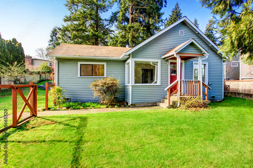 House with wooden deck. Front yard with flower bed and lawn House with wooden deck. Front yard with flower bed and lawn