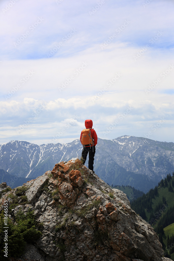 successful woman backpacker hiking on mountain peak cliff successful woman backpacker hiking on mountain peak cliff