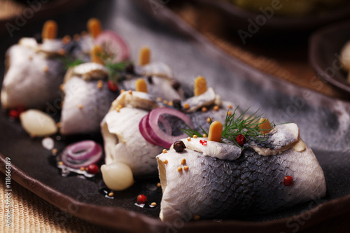 Rolled herring in vinegar, served with onions and pickles. photo
