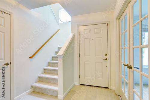 Hallway interior in light tones with hardwood floor and carpet stairs © Iriana Shiyan