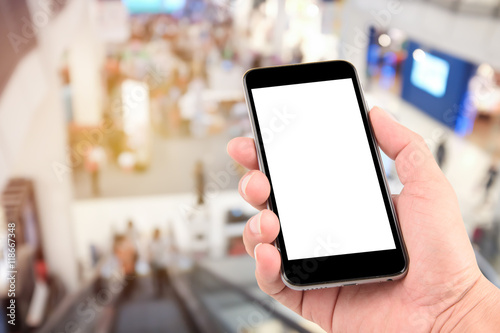 Smart phone with white screen in hand on blurred in shopping mall background