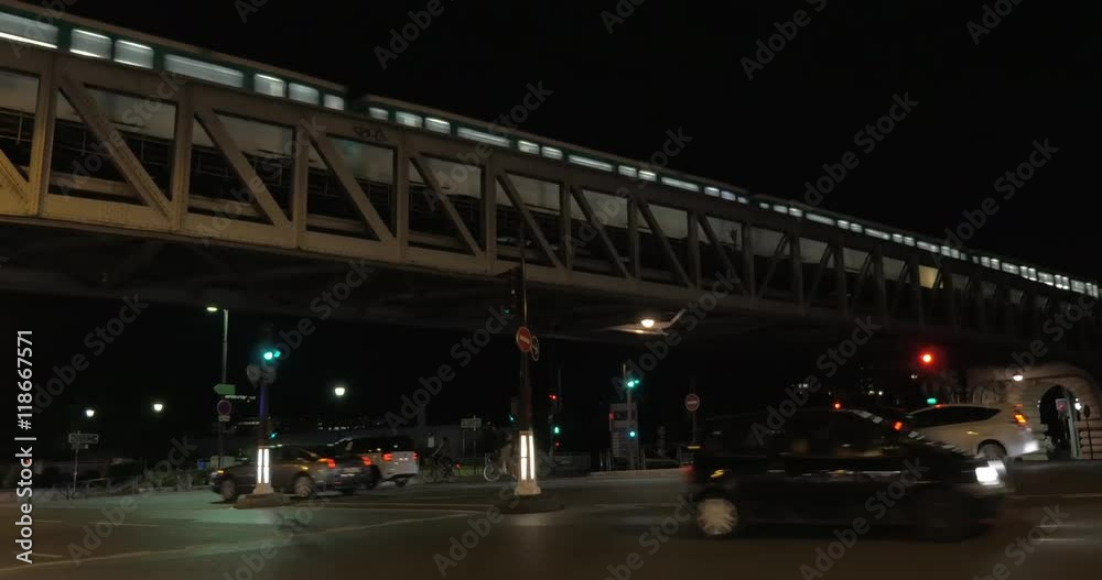 PARIS, FRANCE - SEPTEMBER 06, 2015: Subway train moving across the bridge over the road with car traffic. Night shot PARIS, FRANCE - SEPTEMBER 06, 2015: Subway train moving across the bridge over the road with car traffic. Night shot