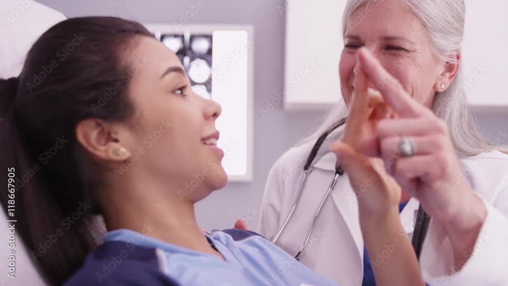 Beautiful hispanic soccer athlete having doctor review sports injury Beautiful hispanic soccer athlete having doctor review sports injury