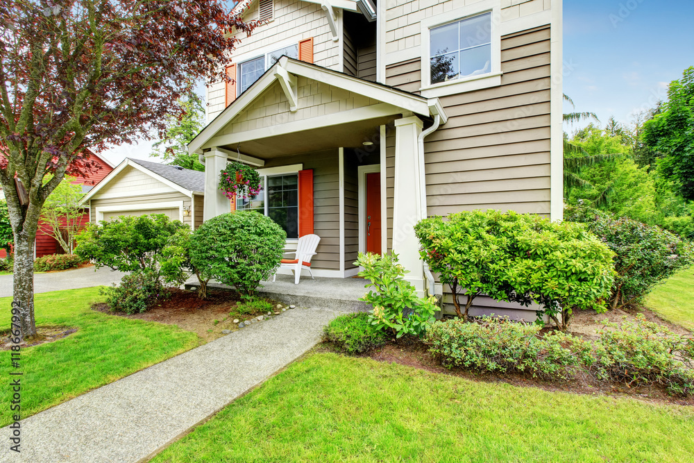 House exterior with siding trim, red entry door and concrete walkway House exterior with siding trim, red entry door and concrete walkway