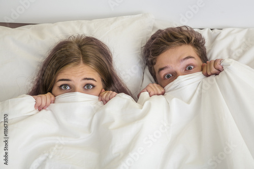 Teen boy and girl in white bed