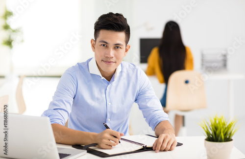 young smiling business man working in office