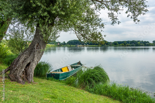 Tablou pe pânză Old boat on the mantova lake