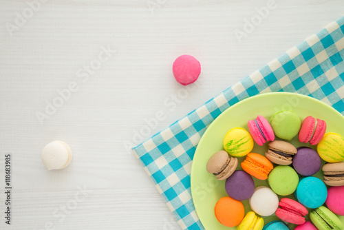 Colorful france macarons on blue tablecloth and white table background