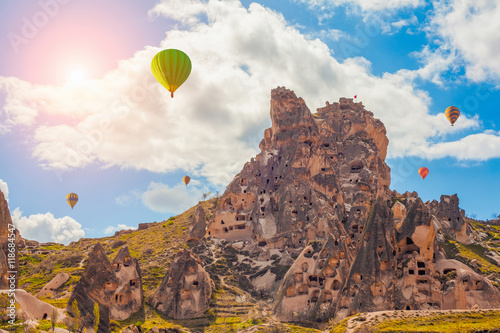 hot air balloons flying over Ortahisar Castle in Cappadocia