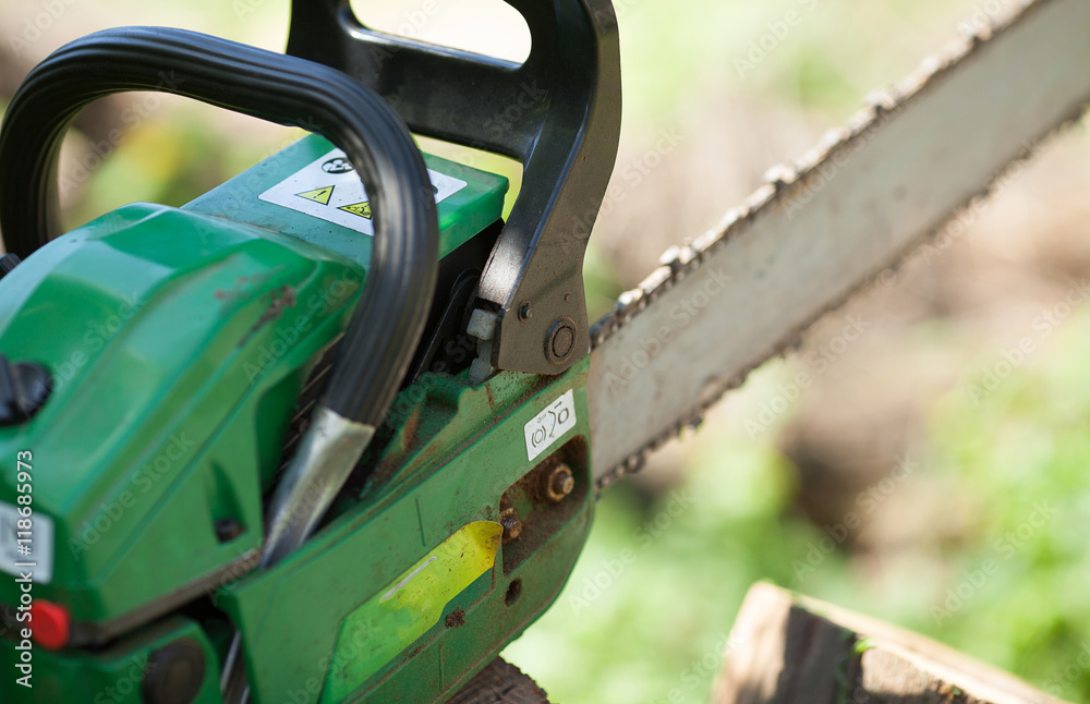 chainsaw tool on green blurred background. chainsaw tool on green blurred background.