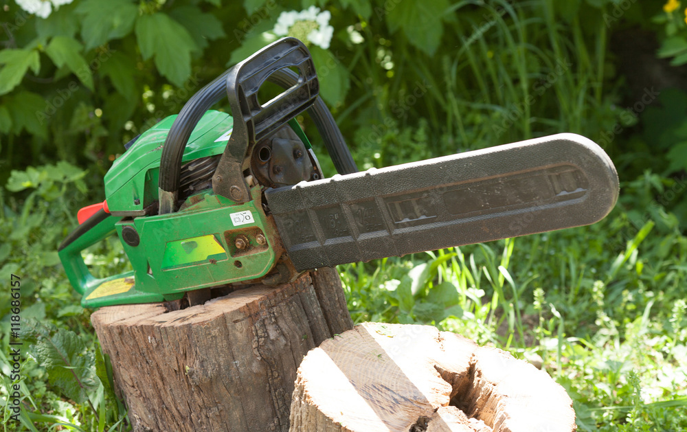chainsaw tool on green blurred background.