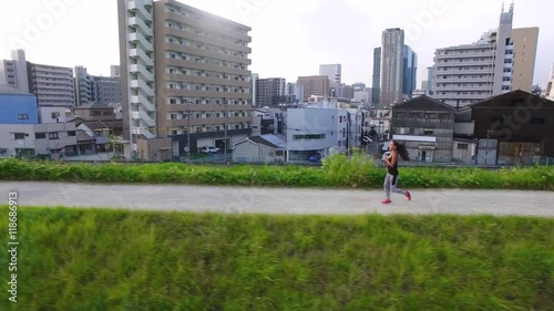 Female runner japanese enjoying healthy exercise drone aerial city background