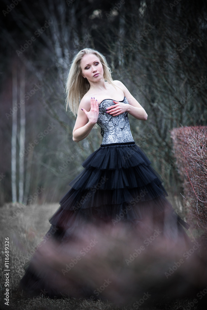 Fototapeta premium Portrait of beautiful girl in black dress in nature