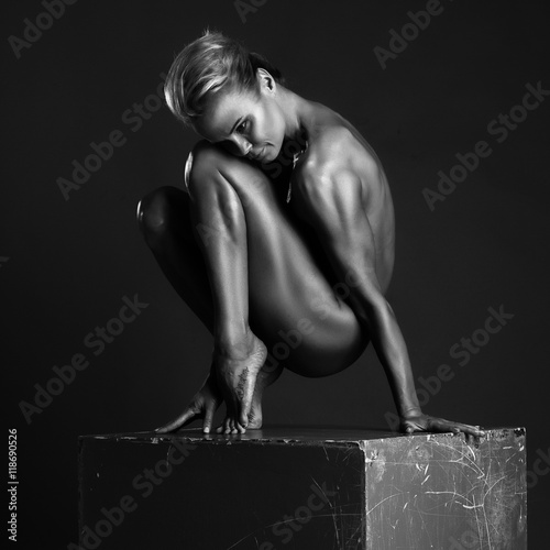 Beautiful woman in the Nude sitting on a cube