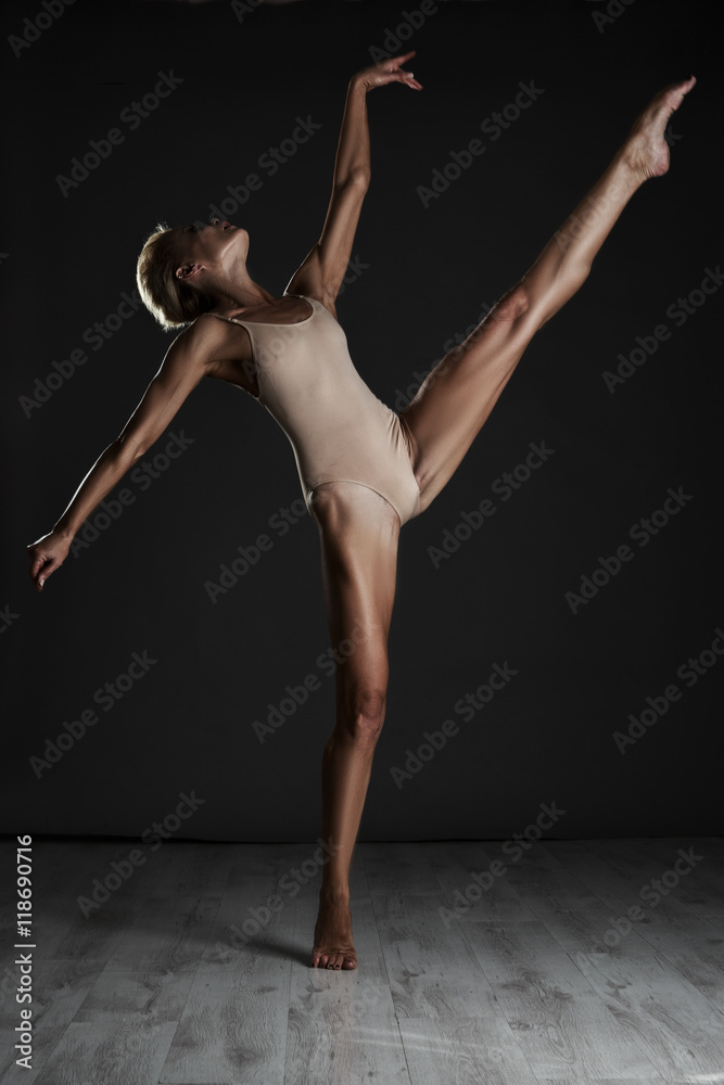 Beautiful woman dancing in Studio on black background