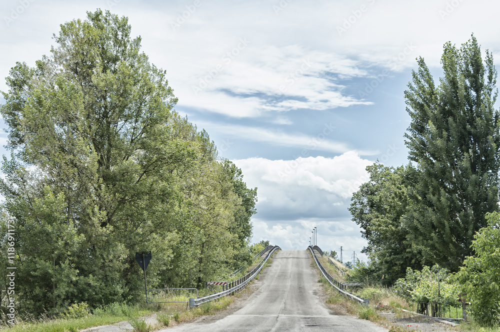 Asphalt uphill road in a countryside space with trees