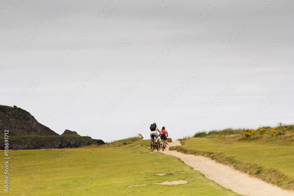 Fototapeta premium Cyclists on a costal path in Cornwall