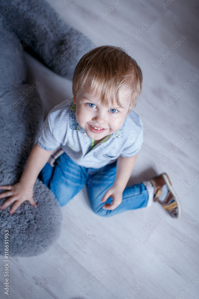 Fototapeta premium Portrait of little boy with a big toy bear in the Studio posing emotions
