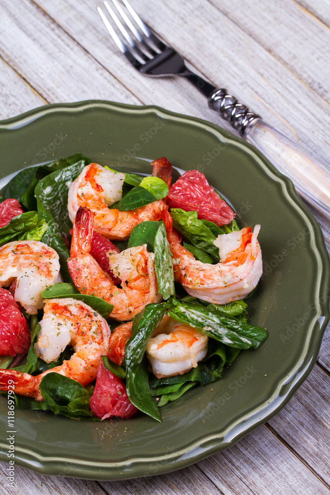 Shrimp, grapefruit and spinach salad in green plate Shrimp, grapefruit and spinach salad in green plate