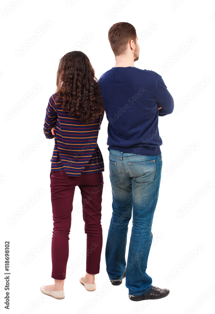 Back view of young embracing couple (man and woman) hug and look into the distance. backside view of person. Isolated over white background. Swarthy girl and a bearded man standing back to back. Back view of young embracing couple (man and woman) hug and look into the distance. backside view of person. Isolated over white background. Swarthy girl and a bearded man standing back to back.