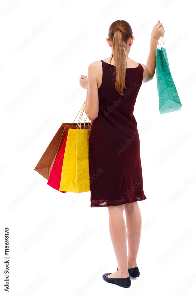 back view of going  woman  with shopping bags . beautiful girl in motion.  backside view of person.  Rear view people collection. Isolated over white background. Slim blonde in a burgundy dress
