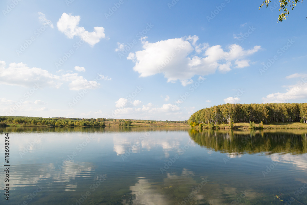 Calm clear lake in the woods. Autumn, september landscape
