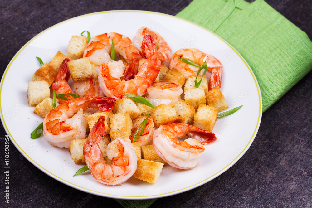 Shrimp with crispy croutons and scallions in white plate Shrimp with crispy croutons and scallions in white plate